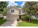 Beautiful home featuring neutral siding, white trim, an attached garage, and mature landscaping at 6125 Desert Peace Ave, Land O Lakes, FL 34639