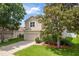 Charming two-story home with a well-manicured lawn, mature landscaping, and a two-car garage at 6125 Desert Peace Ave, Land O Lakes, FL 34639