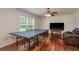 Game room with hardwood flooring and a ceiling fan fixture has lots of space for activities at 6125 Desert Peace Ave, Land O Lakes, FL 34639