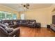 Spacious living room featuring a large leather sectional, ceiling fan, and hardwood floors at 6125 Desert Peace Ave, Land O Lakes, FL 34639