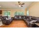 Spacious living room featuring a large sectional sofa, wood floors, and natural light at 6125 Desert Peace Ave, Land O Lakes, FL 34639