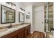 Main bathroom featuring dual sinks, granite countertops, a new shower, and updated fixtures at 6125 Desert Peace Ave, Land O Lakes, FL 34639