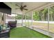 Enjoy this covered and screened patio complete with outdoor seating and ceiling fan with views of the yard at 6125 Desert Peace Ave, Land O Lakes, FL 34639
