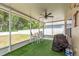 This screened patio features a ceiling fan, a dining set, and a grill for outdoor entertaining at 6125 Desert Peace Ave, Land O Lakes, FL 34639