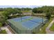 An aerial shot of two tennis courts in a fenced in area surrounded by green space and trees at 6125 Desert Peace Ave, Land O Lakes, FL 34639