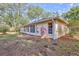 View of the home's backyard featuring grass, foliage and colorful flowers at 6172 Prestwick Ct, Spring Hill, FL 34606
