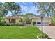 Charming single-story home with a well-manicured lawn, red shutters, and a paved driveway leading to the garage at 6172 Prestwick Ct, Spring Hill, FL 34606