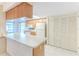 Bright kitchen featuring white countertops, wooden cabinetry, appliances, and a tiled floor at 6172 Prestwick Ct, Spring Hill, FL 34606