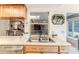 Kitchen sink with double basin, wood cabinets and view to sunroom and dining room at 6172 Prestwick Ct, Spring Hill, FL 34606