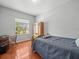 Cozy bedroom featuring a wooden bed frame, wardrobe, desk, and bright window views at 6273 Pinehurst Dr, Spring Hill, FL 34606