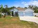 Charming single-Gathering home with a well-manicured lawn, two-car garage, and white and blue paint at 6273 Pinehurst Dr, Spring Hill, FL 34606