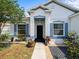 Inviting front porch with a walkway, black door, and colorful landscaping at 6273 Pinehurst Dr, Spring Hill, FL 34606
