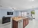 Kitchen features a stainless steel dishwasher and center island sink overlooking a living and dining room at 6273 Pinehurst Dr, Spring Hill, FL 34606