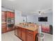 Kitchen boasts stainless steel appliances and a center island sink overlooking the living room at 6273 Pinehurst Dr, Spring Hill, FL 34606