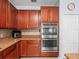 Kitchen features wooden cabinets, granite countertops, mosaic backsplash, and stainless steel appliances at 6273 Pinehurst Dr, Spring Hill, FL 34606