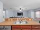 Kitchen features granite countertops and a center island sink overlooking the living room at 6273 Pinehurst Dr, Spring Hill, FL 34606