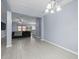Open-concept living and dining space with light gray floors and modern lighting at 6273 Pinehurst Dr, Spring Hill, FL 34606