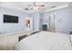 Main bedroom with a tray ceiling, ceiling fan, TV, and walk-in closets at 6273 Pinehurst Dr, Spring Hill, FL 34606
