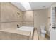 Bright bathroom features a built-in soaking tub, tiled walls, and a separate toilet at 6321 Garland Ct, New Port Richey, FL 34652