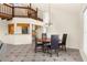 Open dining room with tile floors, and chandelier, next to a kitchen, staircase, and large window at 6321 Garland Ct, New Port Richey, FL 34652