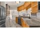 Bright kitchen with granite countertops, wood cabinets, stainless steel appliances, and adjacent spiral staircase at 6321 Garland Ct, New Port Richey, FL 34652