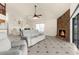 Cozy living room with tile flooring, stone fireplace, ceiling fan, and sliding glass doors to the lanai at 6321 Garland Ct, New Port Richey, FL 34652