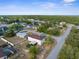 Wide aerial shot of the home and its neighborhood, framed by lush woodlands at 6440 Curtiss Ln, Spring Hill, FL 34609