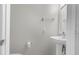 A half bathroom with a pedestal sink, mirror, and tiled floors provides convenience for guests at 6440 Curtiss Ln, Spring Hill, FL 34609