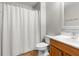 Bright bathroom features a shower with white shower curtain and a wood vanity at 6440 Curtiss Ln, Spring Hill, FL 34609