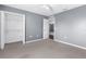 Neutral bedroom features a walk-in closet, ceiling fan, and neutral carpet and walls at 6440 Curtiss Ln, Spring Hill, FL 34609