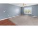 Spacious bedroom featuring a ceiling fan, large window, and neutral carpet flooring at 6440 Curtiss Ln, Spring Hill, FL 34609