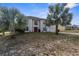 Charming two-story home featuring a red front door, a manicured lawn, and beautiful palm trees at 6440 Curtiss Ln, Spring Hill, FL 34609