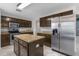 Bright kitchen featuring stainless steel appliances, granite countertops, and dark wood cabinets at 6440 Curtiss Ln, Spring Hill, FL 34609