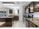 Well-equipped kitchen with island, stone countertops, tile backsplash, and stainless steel appliances at 6440 Curtiss Ln, Spring Hill, FL 34609