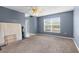 Bright living room with large window, ceiling fan, and neutral carpet flooring at 6440 Curtiss Ln, Spring Hill, FL 34609
