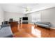 Spacious living room features wood floors, modern sofas, large window, and ceiling fan at 6440 Curtiss Ln, Spring Hill, FL 34609