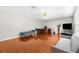 Bright living room featuring hardwood floors, ceiling fan, and comfortable sofas at 6440 Curtiss Ln, Spring Hill, FL 34609
