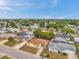 This is an aerial view of the neighborhood showing tree-lined streets and well-maintained homes under a bright blue sky at 7035 Cutty Sark Dr, Port Richey, FL 34668