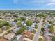 An aerial view showcases a residential neighborhood with green trees and clear blue skies, highlighting the community's layout at 7035 Cutty Sark Dr, Port Richey, FL 34668