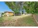 Spacious backyard featuring mature trees and an enclosed lanai, creating a serene outdoor setting at 7035 Cutty Sark Dr, Port Richey, FL 34668
