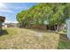 A fully-fenced backyard with mature trees and ample space for outdoor activities at 7035 Cutty Sark Dr, Port Richey, FL 34668