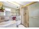 Bathroom with a vanity sink, walk-in shower with gold trim and glass doors, and a tiled floor at 7035 Cutty Sark Dr, Port Richey, FL 34668