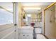 Bright bathroom featuring a single vanity with marble countertop, toilet, and a shower with glass doors at 7035 Cutty Sark Dr, Port Richey, FL 34668