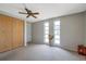 Bedroom with gray carpet, three windows, a closet with wooden doors, and a ceiling fan at 7035 Cutty Sark Dr, Port Richey, FL 34668