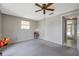 Bedroom with gray carpet, one window, a ceiling fan, and a glimpse into the hallway at 7035 Cutty Sark Dr, Port Richey, FL 34668