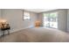 Spacious bedroom with large window, neutral carpet, and access to the backyard at 7035 Cutty Sark Dr, Port Richey, FL 34668
