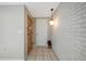 Bright hallway featuring tiled floors, a brick accent wall, and modern lighting at 7035 Cutty Sark Dr, Port Richey, FL 34668