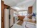 Functional kitchen with wooden cabinets, orange countertops, updated appliances, and tile flooring at 7035 Cutty Sark Dr, Port Richey, FL 34668