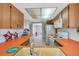 Spacious kitchen with white appliances, wooden cabinets, and a view into the dining area at 7035 Cutty Sark Dr, Port Richey, FL 34668