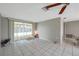 Bright living room boasts neutral walls, tile flooring, and sliding glass door to the outdoor screened patio at 7035 Cutty Sark Dr, Port Richey, FL 34668
